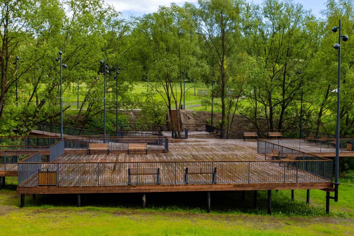 Wooden deck in a landscaped yard with benches and tall trees, Omaha metro