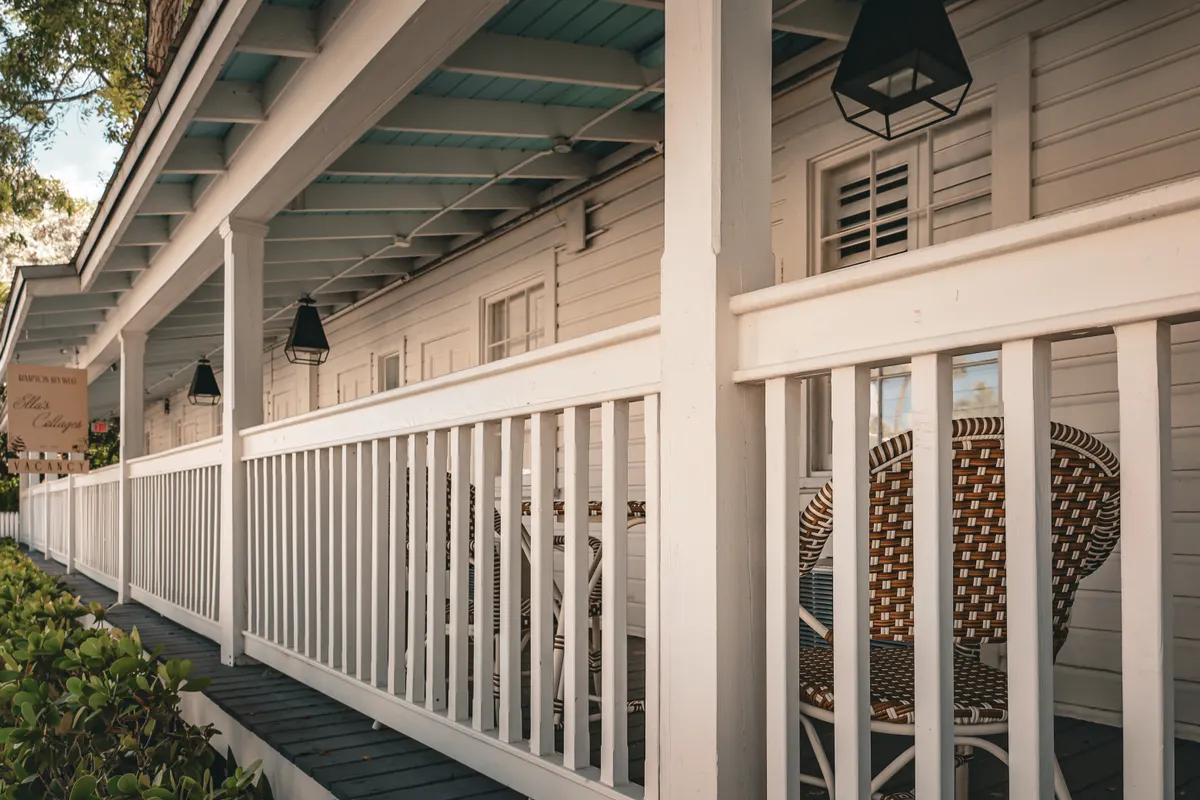 Porch with wicker chairs and repaired white deck railings, west Omaha