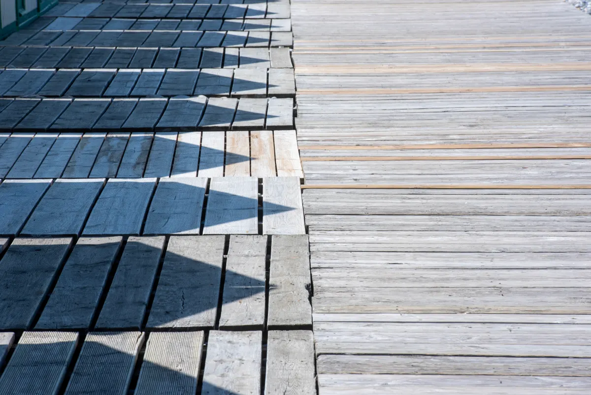 Wooden deck slats with sun-worn shadow patterns, Omaha metro