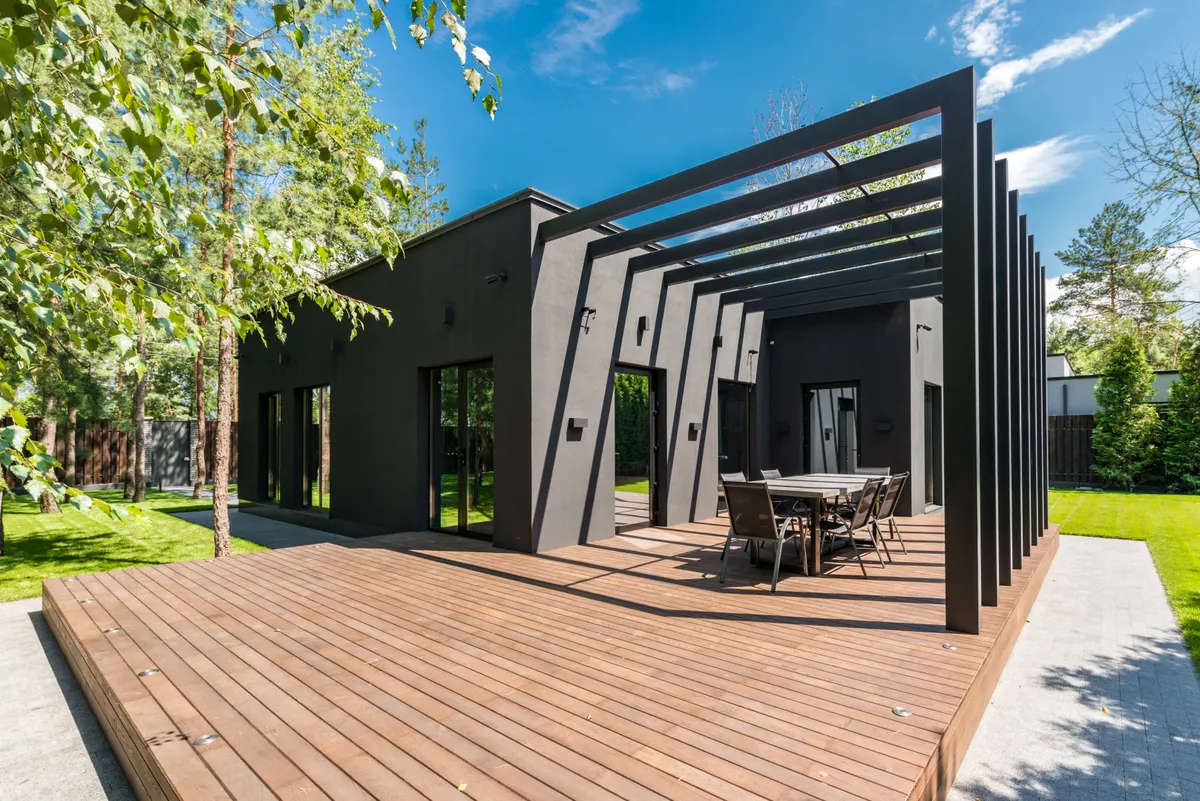 Wooden deck with an outdoor dining set surrounded by greenery